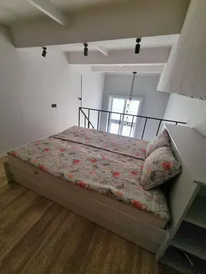 a bedroom with a large bed with a flowery blanket at Cozy Loft in Kaunas