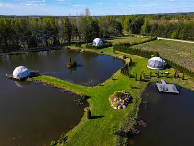 an aerial view of a lake with two domes at Greenery Kupolai in Kalveliai