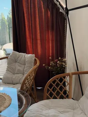 a room with a table and chairs and a curtain at Greenery Kupolai in Kalveliai
