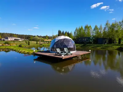 a yurt on a dock in the middle of a river at Greenery Kupolai in Kalveliai