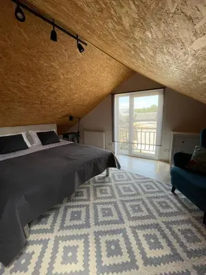 a bedroom with a bed and a large window at Namas senamiestyje in Kėdainiai