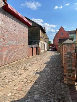 a cobblestone street in a town with buildings at Namas senamiestyje in Kėdainiai