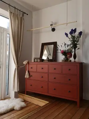 a red dresser in a room with a mirror at Namas senamiestyje in Kėdainiai