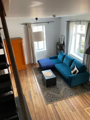 a living room with a blue couch and a table at Namas senamiestyje in Kėdainiai