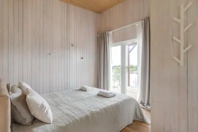 a white bedroom with a bed and a window at Pineplace twins NIDA in Žaugėdai