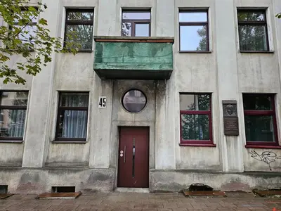 a building with a red door and windows at Kauno apartamentai in Kaunas