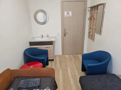a room with two blue chairs and a sink at Kauno apartamentai in Kaunas