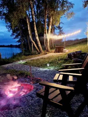 a group of picnic tables next to a fire pit at Glamping Zarasai in Palivarkas