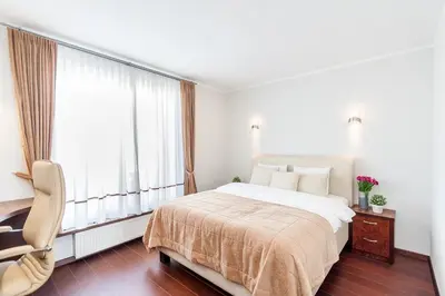 a bedroom with a bed and a chair and a window at Central Apartment in Gedimino Av by URBAN RENT in Vilnius