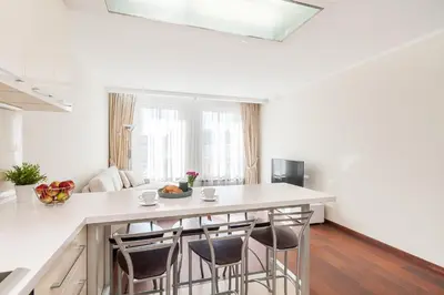 a kitchen with a large white island with bar stools at Central Apartment in Gedimino Av by URBAN RENT in Vilnius