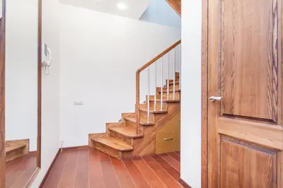 a wooden staircase in a house with a wooden door at Central Apartment in Gedimino Av by URBAN RENT in Vilnius