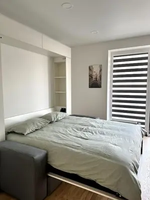 a bedroom with a large bed and a window at Wolfie Apartment, City Center in Vilnius