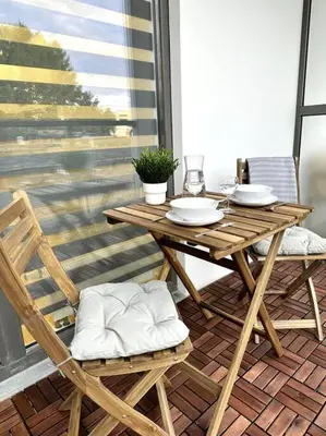 a wooden table and chairs sitting on a patio at Wolfie Apartment, City Center in Vilnius