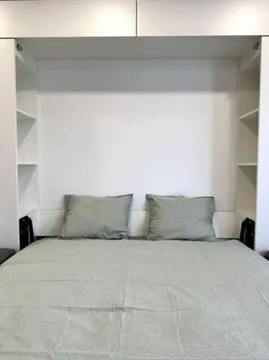 a bedroom with a large bed with white walls at Wolfie Apartment, City Center in Vilnius