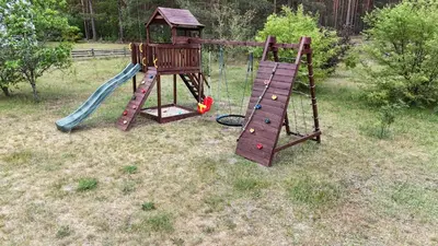 an outdoor playground with a slide and a slideintend at Sena Troba in Druskininkai