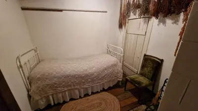 a small bedroom with a bed and a chair at Sena Troba in Druskininkai