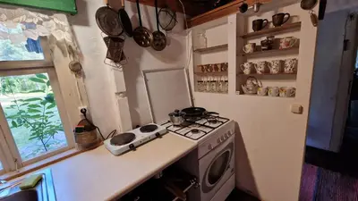 a kitchen with a stove and a stove top oven at Sena Troba in Druskininkai
