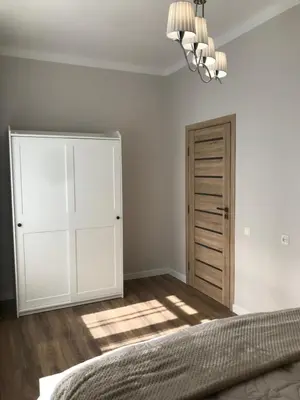 a bedroom with a bed and a closet and a chandelier at Vytauto Septyni in Zarasai