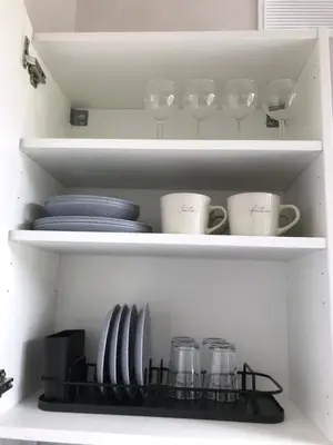 a white cabinet with plates and cups and dishes at Vytauto Septyni in Zarasai