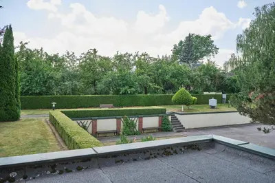 a garden with two benches and a hedge at Jono Pauliaus II piligrimu namai in Raseiniai