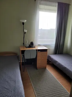 a bedroom with a desk and a bed and a window at Jono Pauliaus II piligrimu namai in Raseiniai