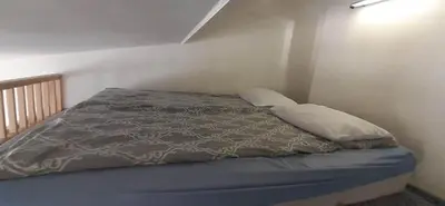 a bed with two pillows and a gray comforter at Loft style apartments in Kaunas center in Kaunas