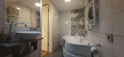 a bathroom with a sink and a tub in it at Loft style apartments in Kaunas center in Kaunas