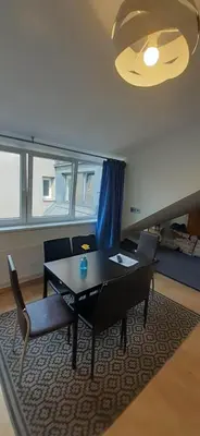 a living room with a table and chairs and a bed at Loft style apartments in Kaunas center in Kaunas