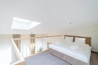 a bedroom with a large white bed and a window at Modern Loft Apartment w/free parking No.2 in Marijampolė