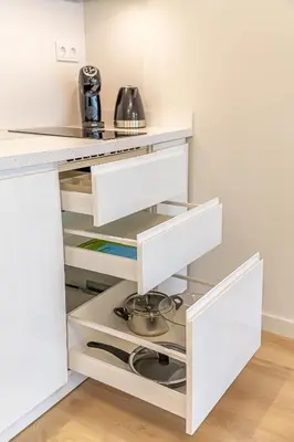 a kitchen with white cabinets and a counter at Modern Loft Apartment w/free parking No.2 in Marijampolė