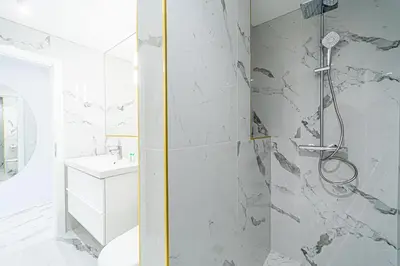 a white bathroom with a shower and a sink at Modern Loft Apartment w/free parking No.2 in Marijampolė