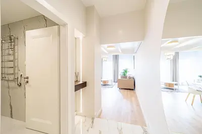 a hallway with a white door and a living room at Modern Loft Apartment w/free parking No.2 in Marijampolė