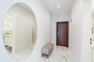 a white hallway with a mirror and a stool at Modern Loft Apartment w/free parking No.2 in Marijampolė