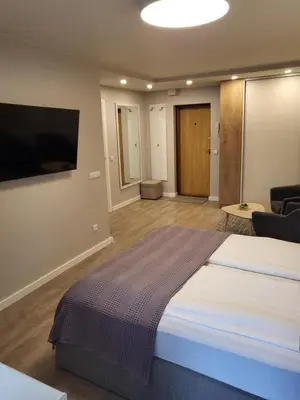 a bedroom with a large bed and a flat screen tv at Vanilės home in Šiauliai