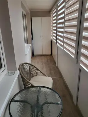 a glass table and a chair in a room at Vanilės home in Šiauliai