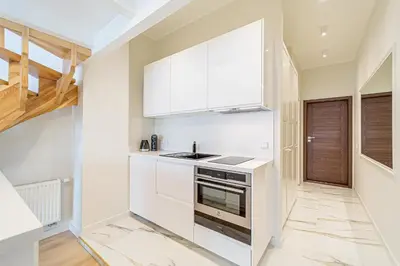 a kitchen with white cabinets and a stove at Modern Loft Apartment w/free parking No.3 in Marijampolė