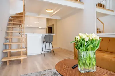 a vase of flowers on a table in a living room at Modern Loft Apartment w/free parking No.3 in Marijampolė
