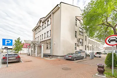 a building on a street with cars parked in front of it at Modern Loft Apartment w/free parking No.3 in Marijampolė