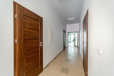 a hallway with a wooden door and a tile floor at Modern Loft Apartment w/free parking No.3 in Marijampolė