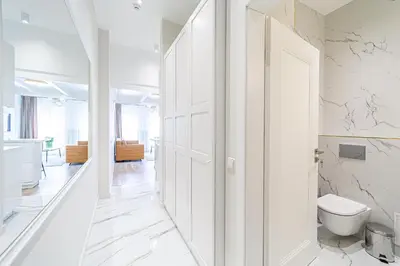 a white bathroom with a toilet and a door at Modern Loft Apartment w/free parking No.3 in Marijampolė