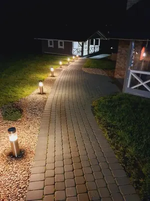 a brick pathway with lights on it at night at GREY PINE HOUSE in Druskininkai