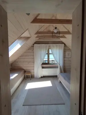 an attic room with a bed and a window at GREY PINE HOUSE in Druskininkai