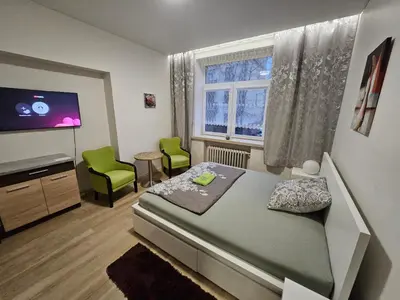 a bedroom with a bed and a flat screen tv at Kauno apartamentai king size bed in Kaunas