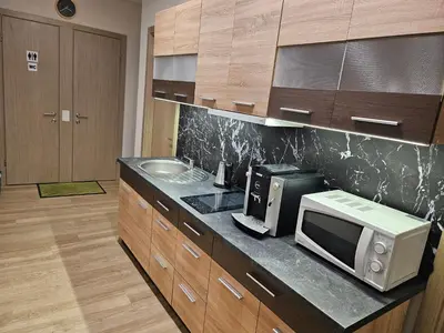 a kitchen with a microwave and a sink at Kauno apartamentai king size bed in Kaunas