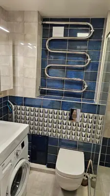 a bathroom with a toilet and a blue tiled wall at Modern Studio Apartment in Marijampolė