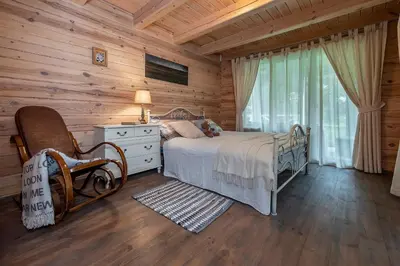 a bedroom with a bed in a log cabin at Vila Shakti in Rudžionys