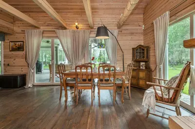 a dining room with a wooden table and chairs at Vila Shakti in Rudžionys