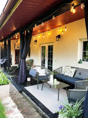 a patio with awning and a table and chairs at Mėta House in Merkinė
