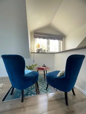 two blue chairs in a living room with a table at Mėta House in Merkinė