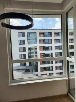 a window with a view of a tall building at Prie Vilneles Apartment in Vilnius